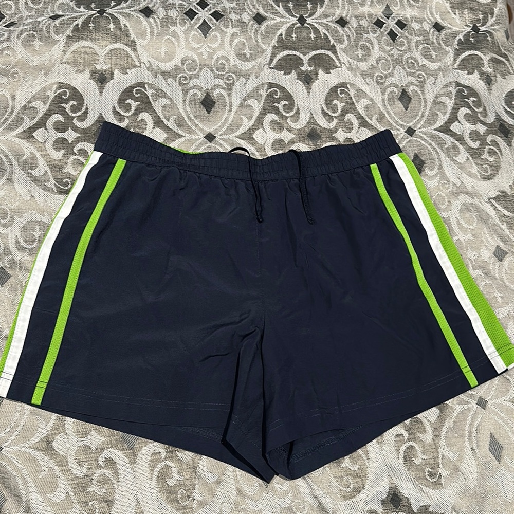Sports shorts navy blue with green and white on the side.